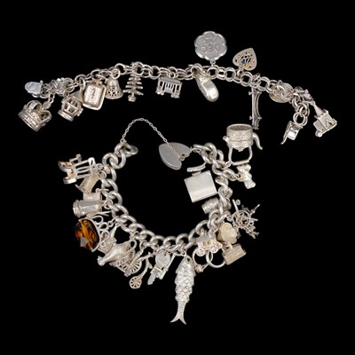 Lot 1258 - A late 20th Century silver charm bracelet,...
