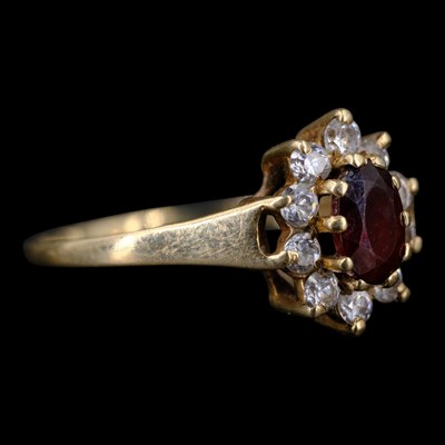 Lot 1346 - A 1990s garnet and cubic zirconia cluster ring,...