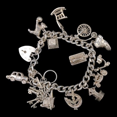 Lot 1286 - A vintage silver charm bracelet, carrying...