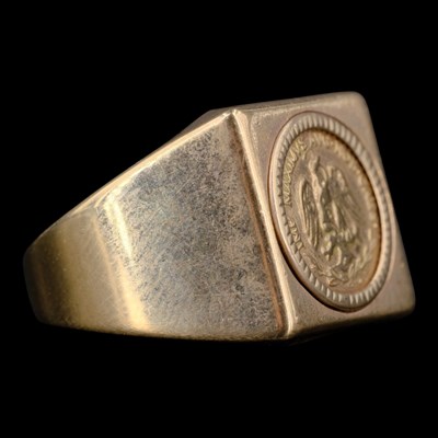 Lot 1426 - A 1970s Neo Classical 9 ct gold coin ring, its...