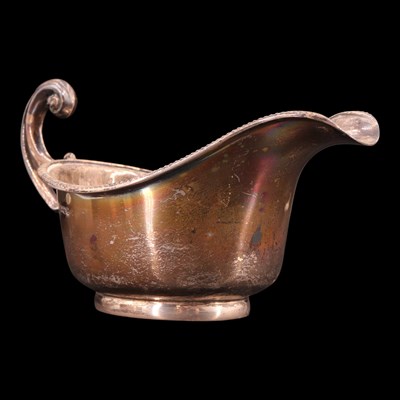 Lot 1187 - A George V silver sauce boat, having a...