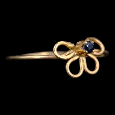 Lot 1324 - A sapphire and yellow metal flowerhead ring,...