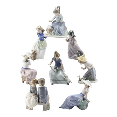 Lot 1028 - A group of nine Nao figurines, including girl...