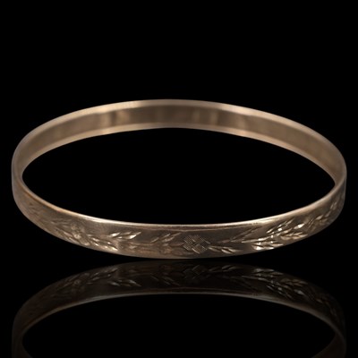 Lot 1258 - A late 20th Century 9 ct gold bangle, bearing...