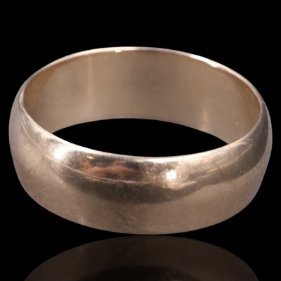 Lot 1277 - A 1960s broad 9 ct gold wedding band, O, 4 g