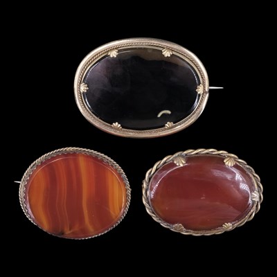 Lot 1412 - Three Victorian banded-agate brooches, each...