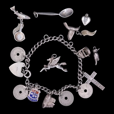 Lot 1215 - A vintage white metal charm bracelet, together...
