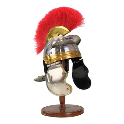 Lot 483 - A miniature model Roman helmet and stand, 26 cm