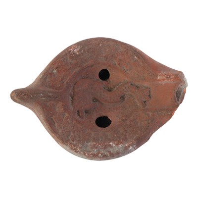 Lot 926 - A Roman terracotta oil lamp, decorated in...
