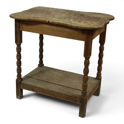Lot 1663 - An early 20th Century carved oak occasional...